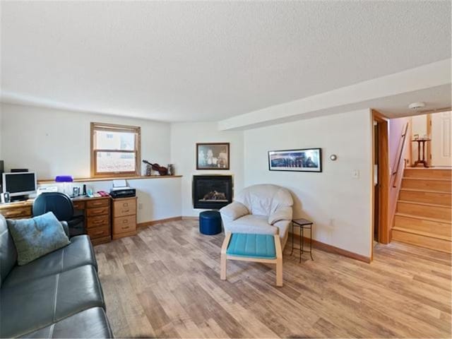 living room with light hardwood / wood-style floors and a textured ceiling