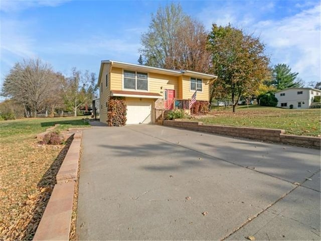 raised ranch with a garage and a front lawn