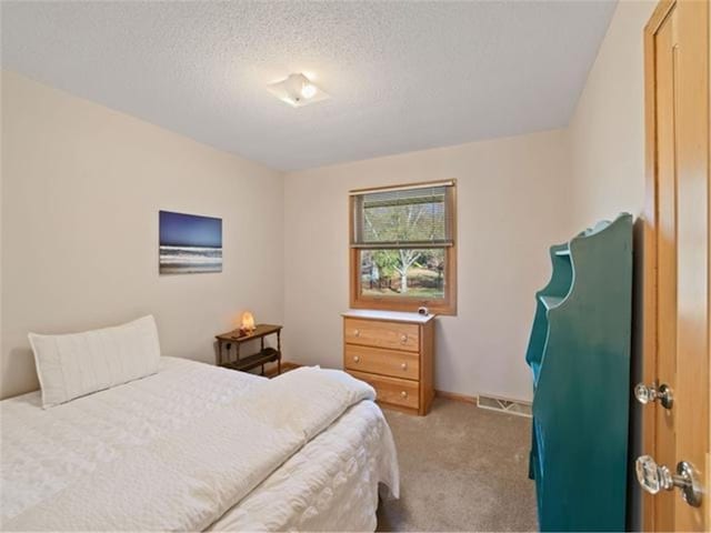 carpeted bedroom with a textured ceiling