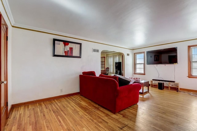 living room with crown molding and light wood-type flooring