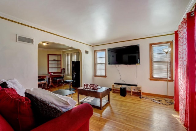 living room with crown molding, plenty of natural light, and hardwood / wood-style floors