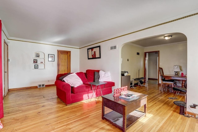 living room featuring crown molding and light hardwood / wood-style flooring