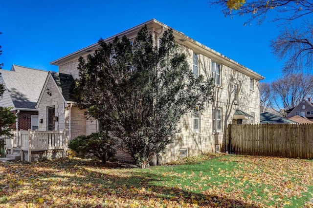 view of side of property with a yard and a deck