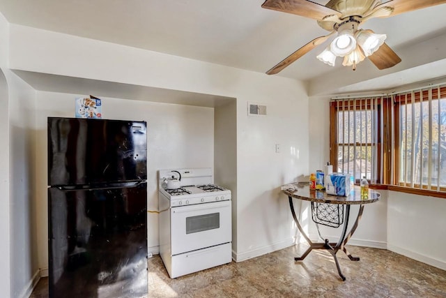 kitchen with black fridge, ceiling fan, and white gas range