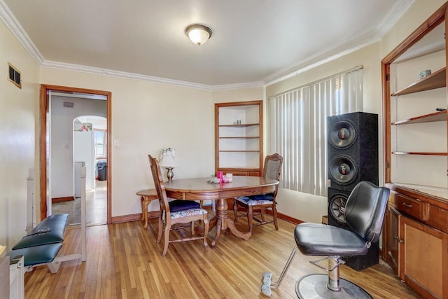 dining space featuring ornamental molding and light wood-type flooring