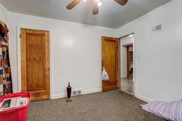 unfurnished room featuring ceiling fan and dark carpet