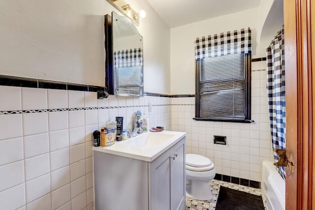 bathroom with vanity, tile patterned floors, tile walls, and toilet