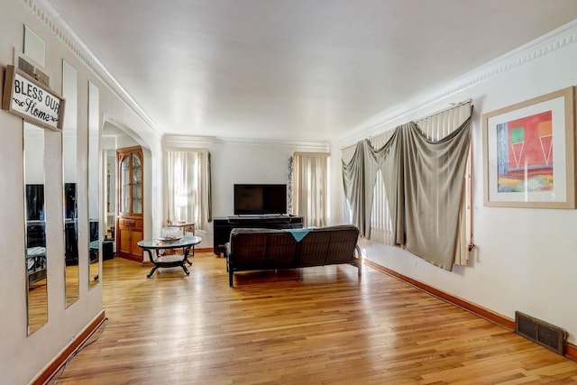 living room with crown molding and light wood-type flooring