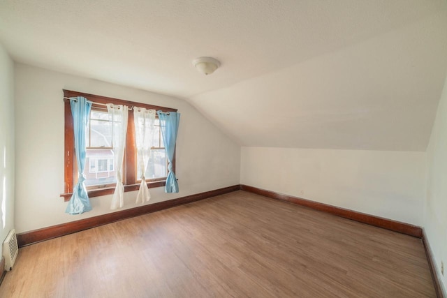 bonus room with lofted ceiling and hardwood / wood-style flooring