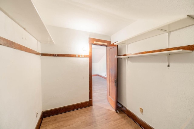 walk in closet with light hardwood / wood-style flooring