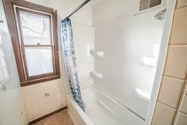 bathroom featuring shower / bath combo and tile walls