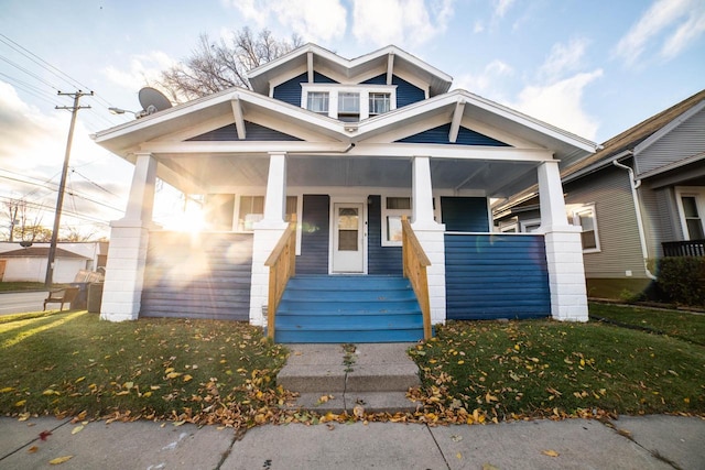 view of front of property featuring a front yard and covered porch