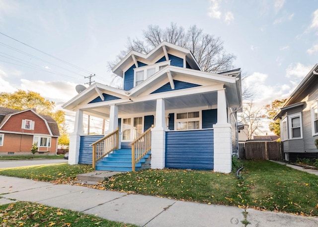 view of front of house featuring covered porch and a front yard