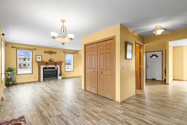 unfurnished living room featuring light hardwood / wood-style floors and an inviting chandelier