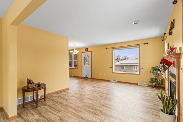 living room featuring light hardwood / wood-style floors and an inviting chandelier