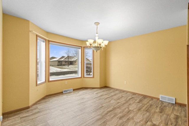 unfurnished dining area featuring light hardwood / wood-style floors and a chandelier