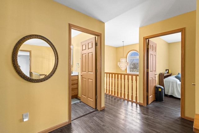 corridor featuring a chandelier and dark hardwood / wood-style floors