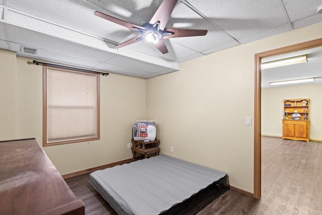 bedroom featuring a paneled ceiling, hardwood / wood-style flooring, and ceiling fan