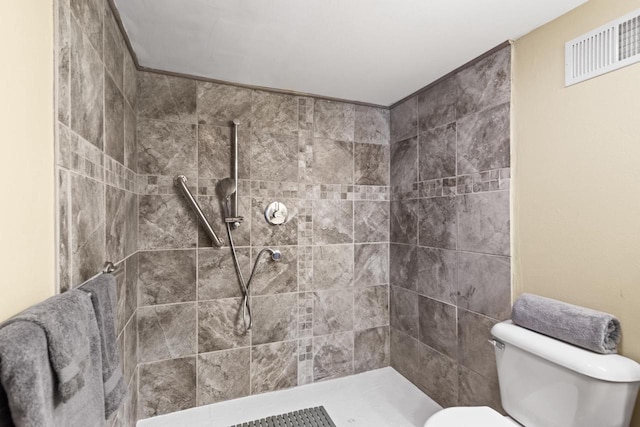 bathroom featuring toilet and tiled shower