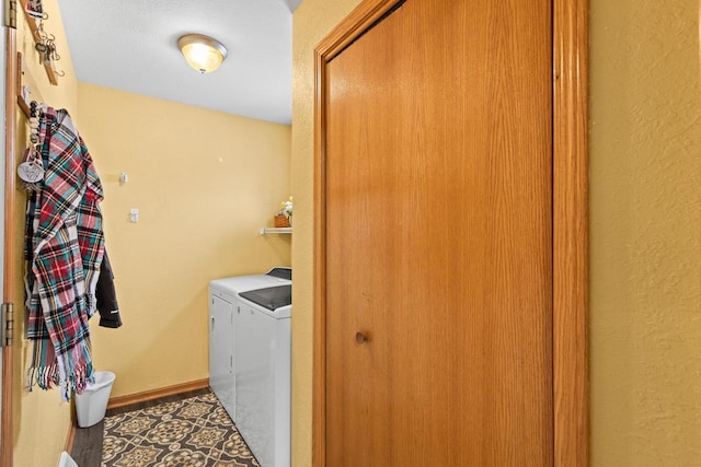 laundry area with separate washer and dryer and dark tile patterned flooring