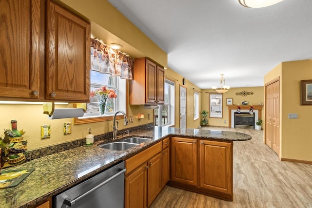 kitchen featuring dishwasher, light hardwood / wood-style floors, kitchen peninsula, and sink