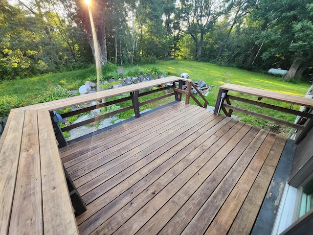 wooden terrace featuring a lawn