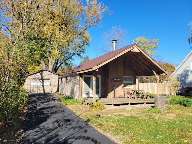 view of front of property featuring a front lawn and an outbuilding