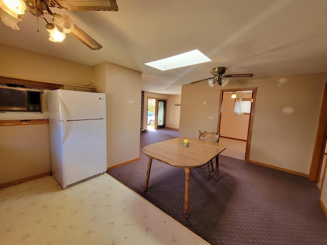 unfurnished dining area featuring ceiling fan and a skylight