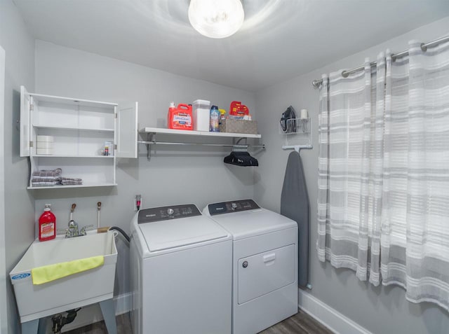 laundry area with washer and dryer, sink, and dark hardwood / wood-style flooring