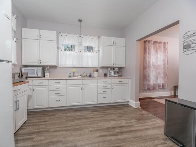 kitchen with white cabinetry, white appliances, decorative light fixtures, and light wood-type flooring