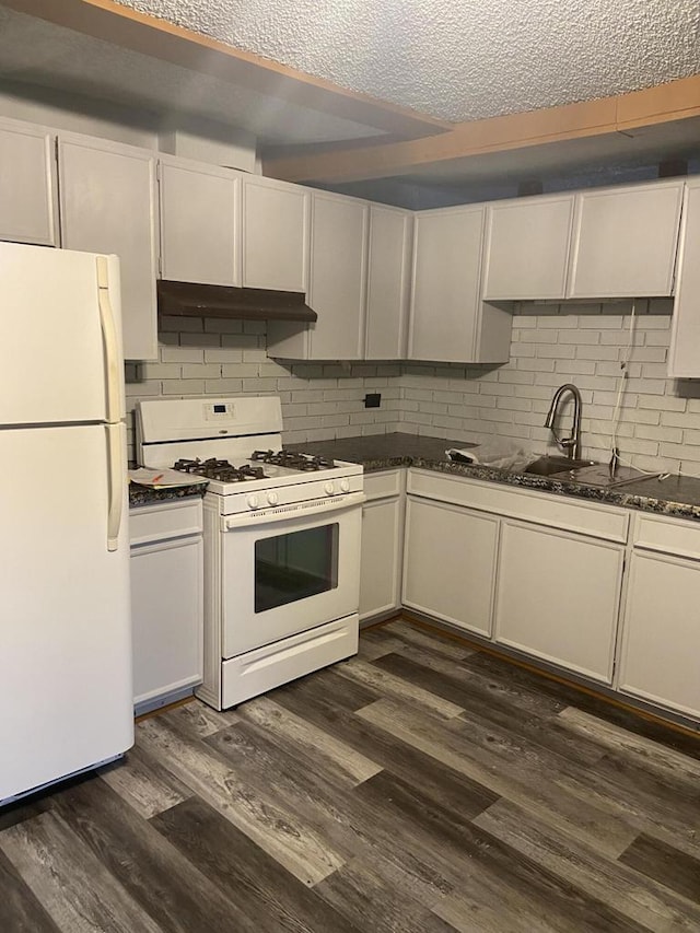 kitchen featuring dark hardwood / wood-style floors, a textured ceiling, white appliances, and tasteful backsplash