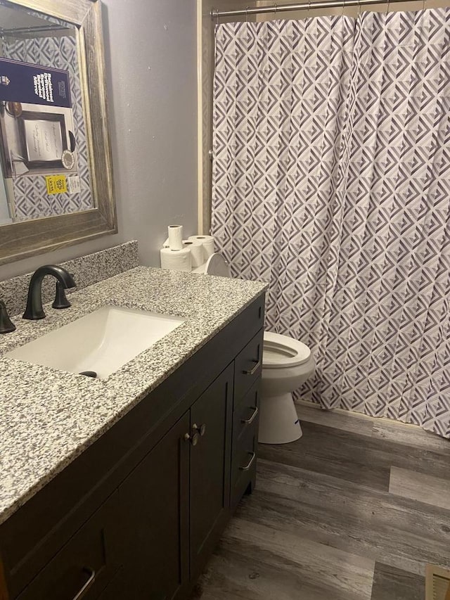 bathroom with vanity, hardwood / wood-style flooring, toilet, and a shower with curtain