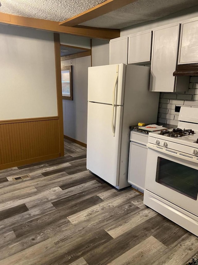 kitchen with white appliances, tasteful backsplash, dark hardwood / wood-style floors, and white cabinets