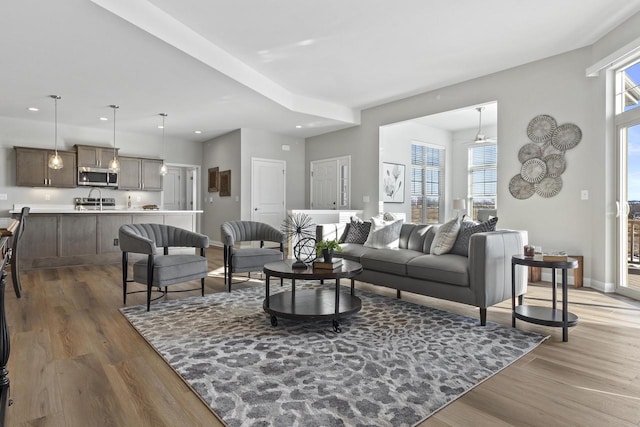 living room with light wood finished floors, baseboards, and recessed lighting