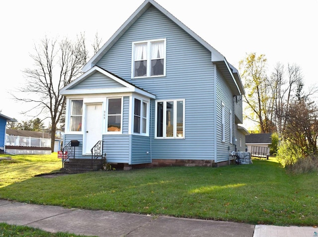 view of front of property featuring a front lawn and a storage unit