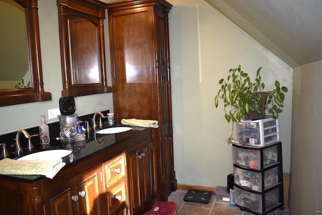 bathroom featuring tile patterned flooring, vanity, and lofted ceiling