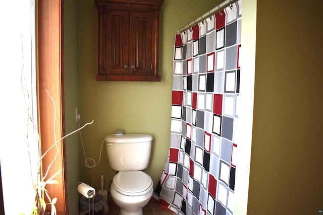 bathroom featuring tile patterned flooring, a shower with shower curtain, and toilet