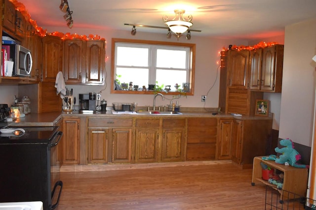 kitchen featuring light hardwood / wood-style floors, rail lighting, sink, and electric range