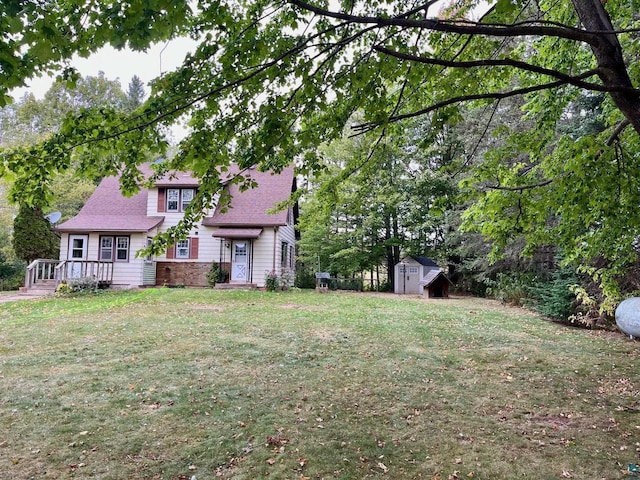 view of front of home featuring a front yard and a shed