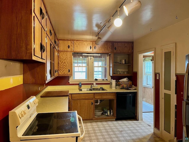 kitchen featuring sink, track lighting, dishwasher, and stove