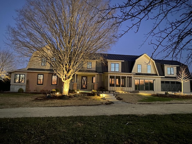 view of front facade featuring metal roof, a standing seam roof, and a gambrel roof