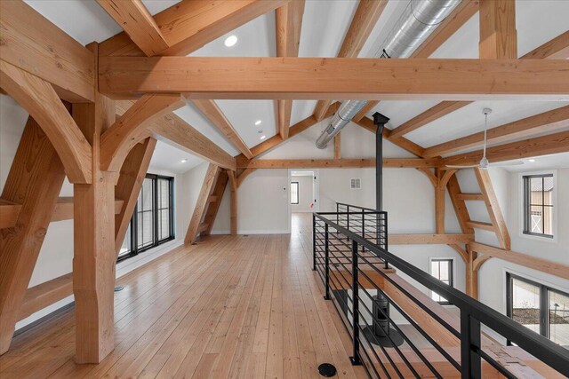 bonus room featuring high vaulted ceiling, light wood-type flooring, beam ceiling, and a healthy amount of sunlight