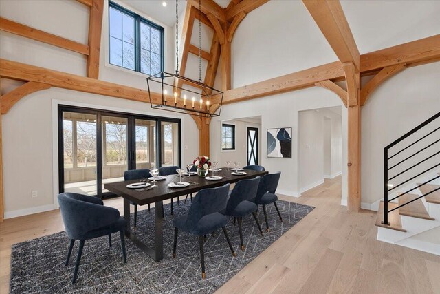 dining area with wood finished floors, plenty of natural light, and stairs