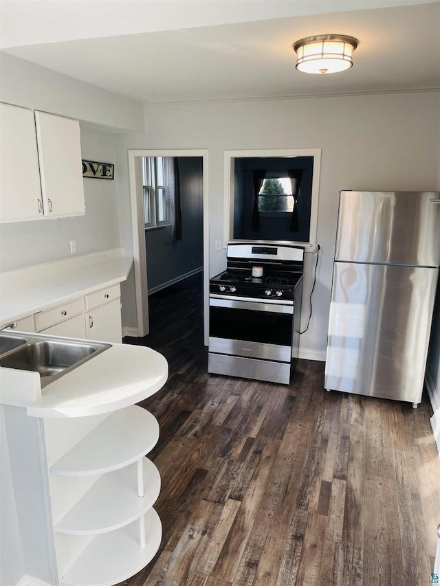 kitchen with white cabinets, stainless steel appliances, sink, and dark hardwood / wood-style flooring