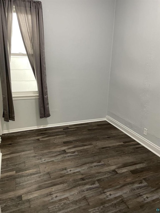 spare room featuring dark wood-type flooring