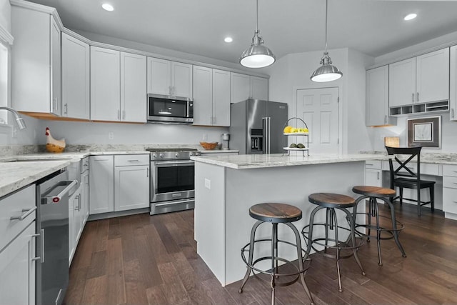 kitchen featuring a kitchen island, dark wood-type flooring, stainless steel appliances, sink, and white cabinetry