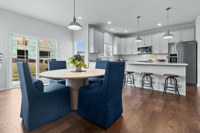 dining space with dark hardwood / wood-style floors and sink