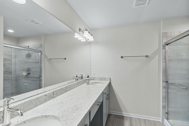 bathroom featuring a shower with door, vanity, and wood-type flooring