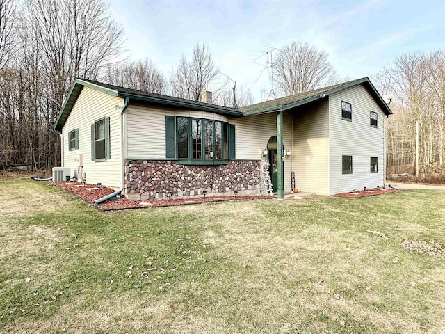 view of front of property with a front lawn and cooling unit