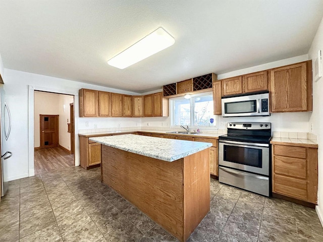 kitchen with appliances with stainless steel finishes, a center island, and sink